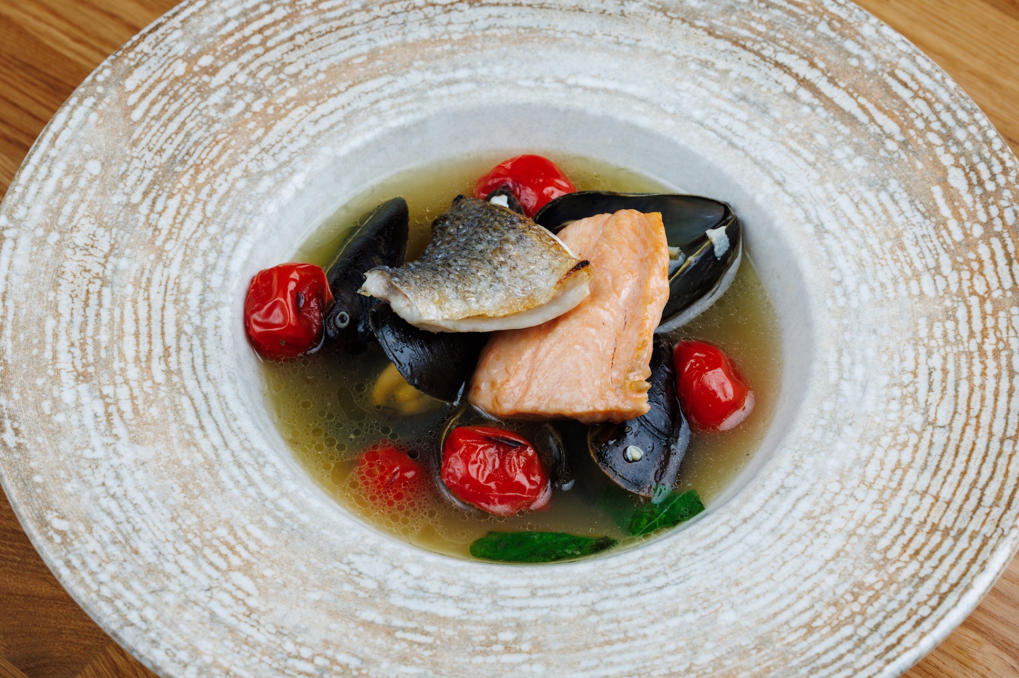 Zuppa di pesce leggera con salmone, orata, cozze e pomodorini italiani