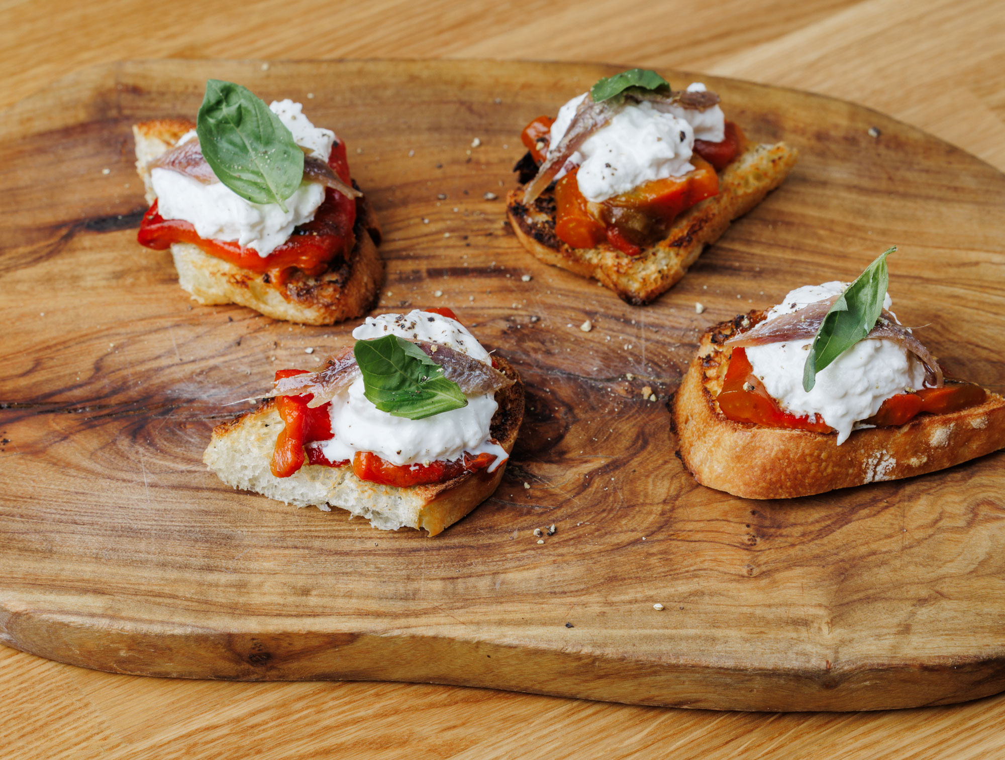 Bruschetta con peperoni grigliati, stracciatella e acciughe